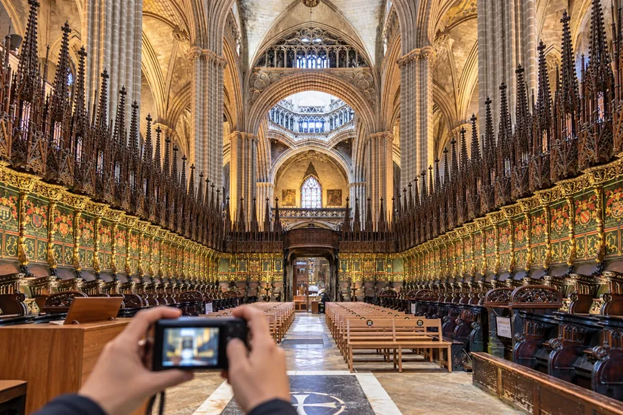 Látogató építészeti részleteket fényképez a barcelonai katedrálisban